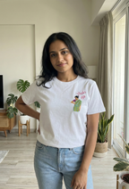 Woman wearing a white t-shirt with a Thaki Gai graphic design on left chest
